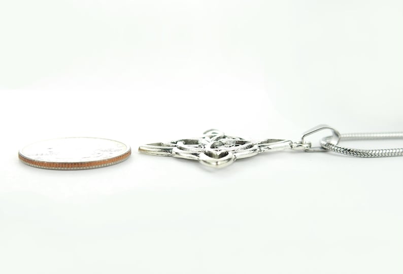 May include: Silver Celtic knot pendant necklace with a silver chain. The pendant is about the size of a US quarter.