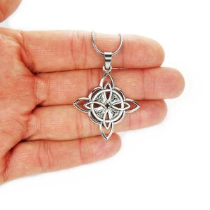 May include: A silver Celtic knot pendant necklace with a four-pointed star design. The pendant is intricate and detailed, with a smooth, polished finish.