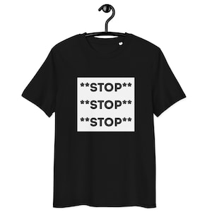 May include: Black t-shirt with the word "STOP" repeated three times in white, bold text within a white square. The shirt is hanging on a black hanger.