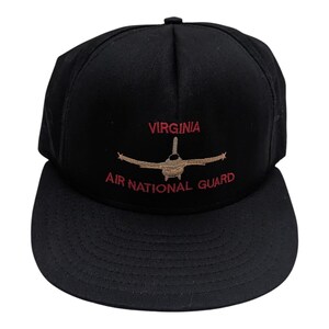 Puede incluir: Gorra de béisbol negra con bordado rojo que dice "VIRGINIA AIR NATIONAL GUARD" y una imagen bordada marrón de un avión de combate.
