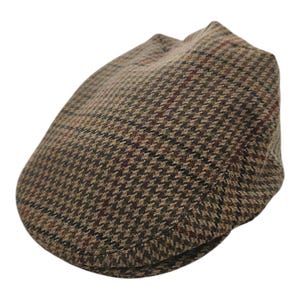 May include: A brown tweed flat cap with a classic houndstooth pattern. The cap features a rounded crown and a short, stiff brim. The fabric has a mix of brown, tan, and burgundy threads.