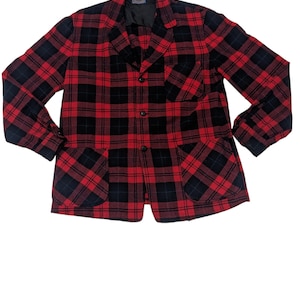 May include: A red and black plaid button-up jacket with two large patch pockets.