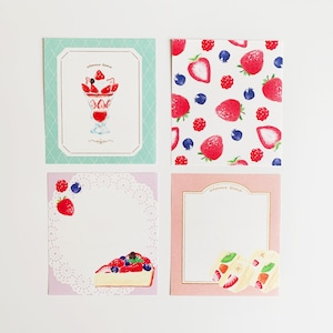 Op de afbeelding: Vier vierkante kaarten met een aardbeien thema. De kaarten hebben een witte achtergrond met een roze, groene of witte rand. De kaarten bevatten illustraties van aardbeien, blauwe bessen en desserts. De tekst "sweet time" is op de kaarten gedrukt.