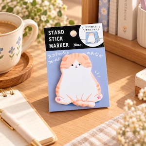 May include: A pack of 30 sticky notes featuring a die-cut illustration of a ginger and white Scottish Fold cat. The packaging is labeled STAND STICK MARKER and includes Japanese text. The cat design has a white belly, orange striped head, and pink paw pads.