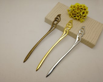 May include: Three decorative hair sticks with ornate, openwork designs. The sticks are made of metal and are available in gold, silver, and bronze.