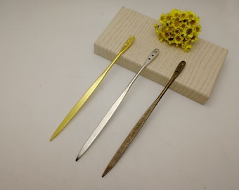 Può includere: Tre forcine per capelli in metallo dorato, argentato e bronzo. Ogni forcina ha un design sottile e appuntito con una parte superiore decorativa. La forcina dorata ha una parte superiore piena, mentre quella argentata ha tre piccoli fori e quella bronzata ha tre piccoli fori.