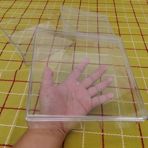 Puede incluir: Tres cajas de almacenamiento de plástico transparente con tapas. Las cajas están apiladas una encima de la otra. La caja más grande está en la parte inferior y la caja más pequeña está en la parte superior.