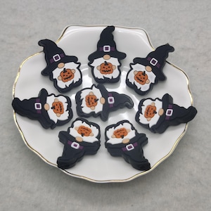 May include: Nine black and orange Halloween gnome charms with pumpkin faces and black witch hats.