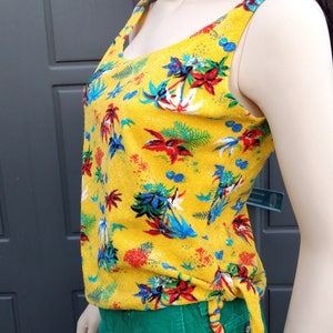 May include: A yellow sleeveless top with a tropical print and a green corduroy skirt.