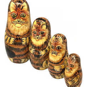 May include: Set of four nesting dolls, each painted with a different size tabby cat. The largest doll is brown and orange with black stripes, and the smallest doll is a light brown with black stripes.