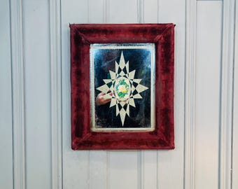 Antique French red velvet bevelled wall mirror with motif