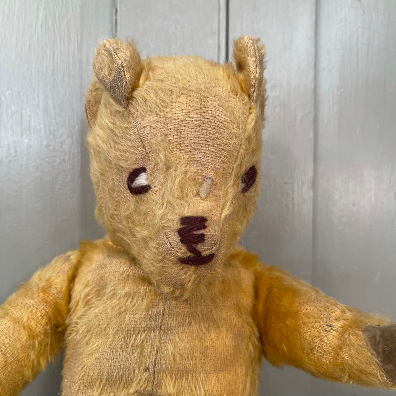 Puede incluir: Un oso de peluche vintage con ojos marrones y una nariz cosida. El oso est&aacute; hecho de un material suave y de felpa y tiene un aspecto desgastado y muy querido.