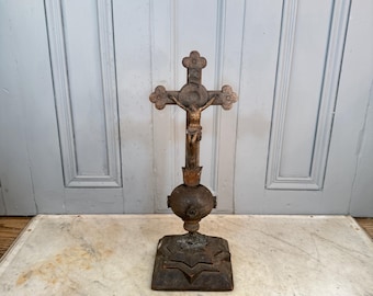 Puede incluir: Crucifijo de madera antiguo con una figura de Jesús tallada. La cruz tiene detalles florales decorativos y se apoya sobre una base ornamentada. La pieza es de madera oscura y tiene una estética vintage, probablemente de una iglesia.