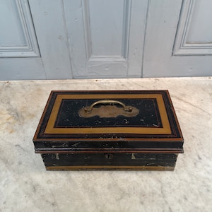 Caja antigua victoriana de Toleware con una colección variada de dentaduras postizas de dentistas.