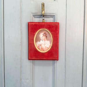 Antique portrait of girl holding dove in red velvet frame