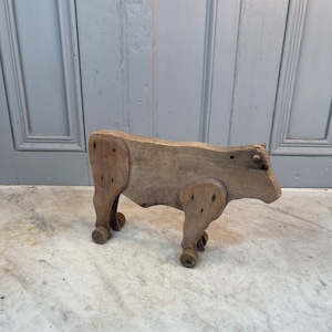Antique French handmade wooden hand carved toy bull on wheels