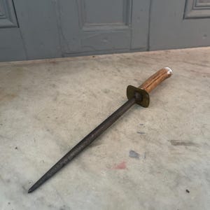 Puede incluir: Un afilador de cuchillos vintage de acero con mango de asta de ciervo marr&oacute;n y detalles en lat&oacute;n.