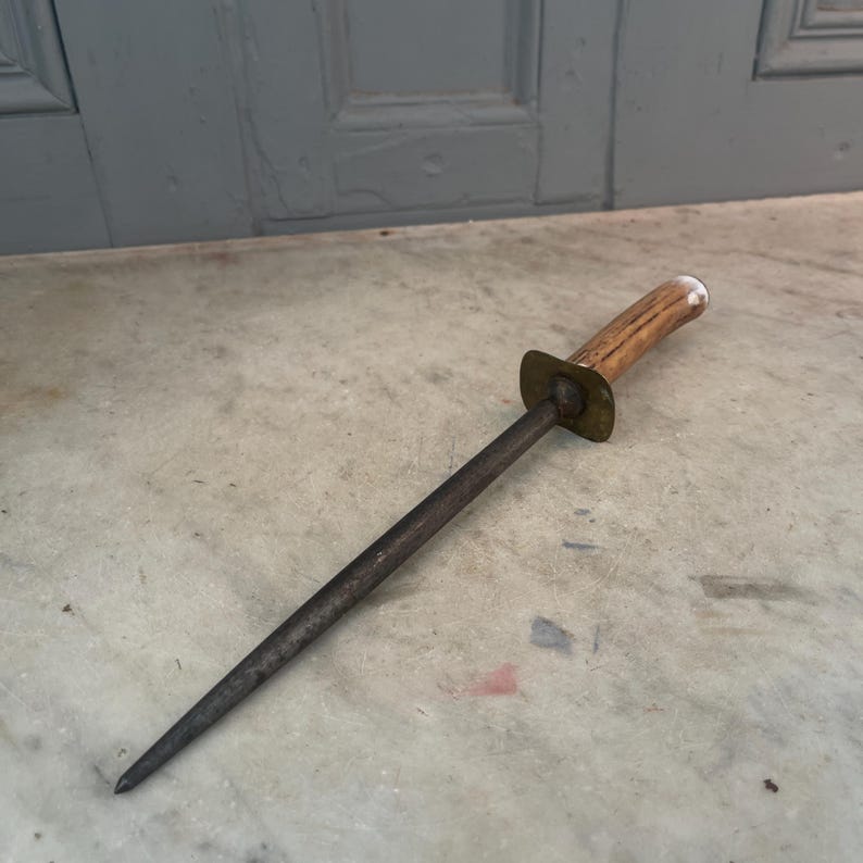 Puede incluir: Un afilador de cuchillos vintage de acero con mango de asta de ciervo marr&oacute;n y detalles en lat&oacute;n.