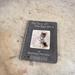 May include: A vintage copy of "The Tale of Two Bad Mice" by Beatrix Potter. The book has a gray cover with the title and author's name in white text. The cover features a color illustration of a mouse. Published by F. Warne & Co.