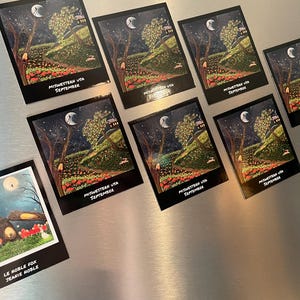 May include: A set of nine magnets featuring whimsical illustrations of a moonlit forest scene with a small house. The magnets are rectangular and have a black border. The text on the magnets reads "Midwestern USA September" and "Le Noble Fox Jeanie Noble".