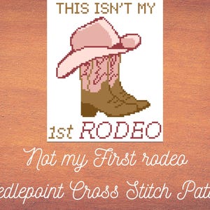 May include: A cross-stitch pattern featuring a cowboy hat and boots. The text reads "THIS ISN'T MY 1st RODEO". Below, the text says "Not my First rodeo Needlepoint Cross Stitch Pattern". The design is in shades of pink, brown, and white.