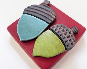 clique tile - acorns on red