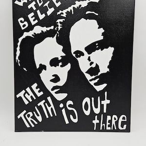 May include: Black and white canvas art with the text "I WANT TO BELIEVE" and "THE TRUTH IS OUT THERE". The artwork features two silhouetted faces. The canvas measures 16x20 inches.
