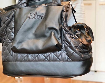 Könnte beinhalten: Schwarzer gesteppter Tiertransportbeutel mit Reißverschlussöffnung und einem kleinen Hund, der herausschaut. Der Beutel hat einen schwarzen Ledergriff und der Name "Elvis" ist auf der Vorderseite gestickt.