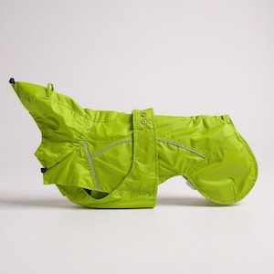 May include: A bright green dog raincoat. The coat has a reflective strip and two button closures. The dog coat is designed to protect a dog from the rain and wind. The coat is made of a lightweight material.