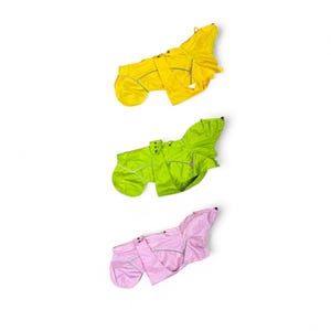 May include: Three dog raincoats in different colors: yellow, green, and pink. The raincoats are designed to keep dogs dry and comfortable in wet weather.