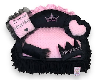 May include: A pink and black dog bed shaped like a couch with a crown and the name "Princess Ming Ming" embroidered on it.