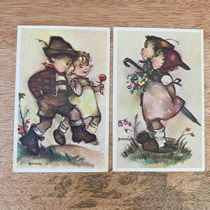 May include: Two vintage postcards featuring illustrations of children. The first postcard shows a boy and girl walking together, while the second postcard shows two girls standing side-by-side. Both postcards have the word "Bonnie" printed at the bottom.