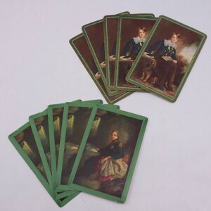 May include: Two stacks of playing cards with green borders. The top stack features a portrait of a person in a dark blue uniform with a white collar. The bottom stack features a portrait of a person in a military uniform sitting at a table.