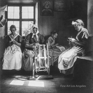 Puede incluir: Fotografía en blanco y negro de cuatro mujeres sentadas en una habitación, tres de ellas trabajan con hilo con una rueca. La habitación tiene una ventana y una pintura religiosa en la pared.