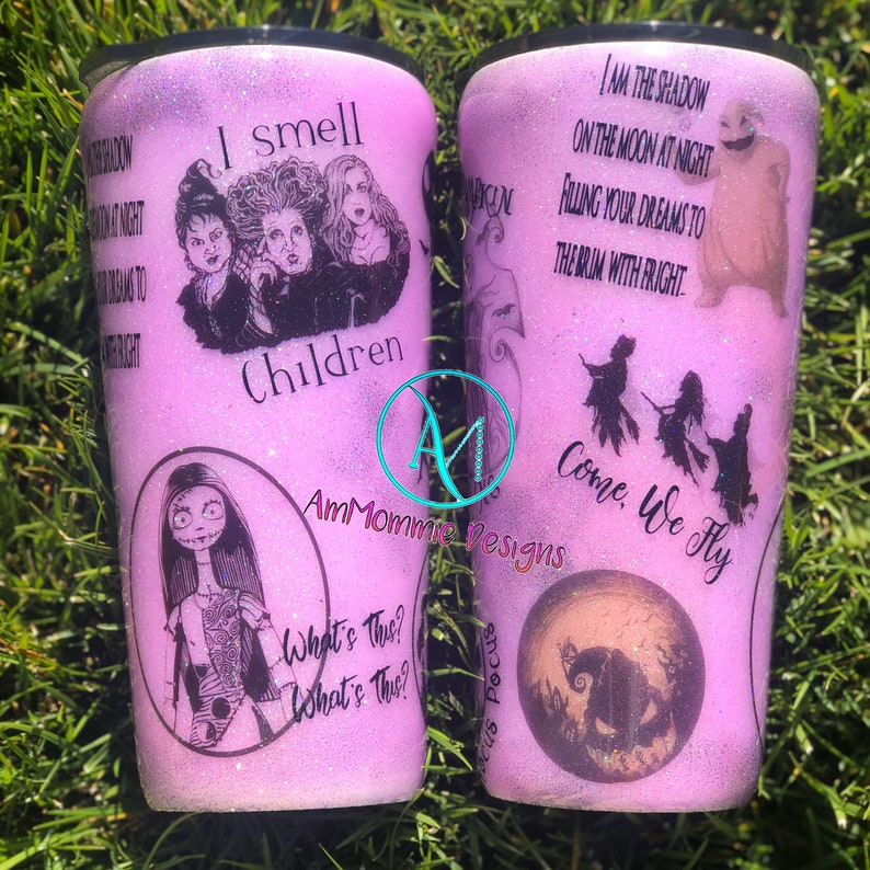 May include: Two purple glitter tumblers with Halloween-themed designs. One features the Sanderson sisters from Hocus Pocus with the text "I smell children". The other features Jack Skellington from The Nightmare Before Christmas with the text "I am the shadow on the moon at night, filling your dreams to the brim with fright. Come, we fly."
