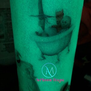 Puede incluir: Un vaso verde que brilla en la oscuridad con un dise&ntilde;o blanco de un personaje de la pel&iacute;cula "Pesadilla antes de Navidad" en una ba&ntilde;era. El vaso tiene el texto "Am Mommie Designs" en la parte inferior.