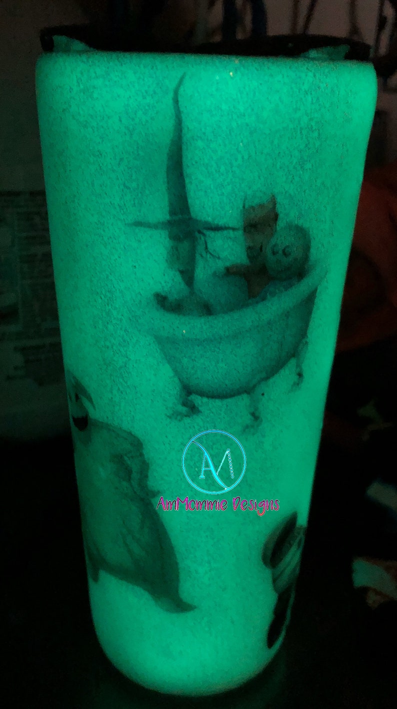 Puede incluir: Un vaso verde que brilla en la oscuridad con un dise&ntilde;o blanco de un personaje de la pel&iacute;cula "Pesadilla antes de Navidad" en una ba&ntilde;era. El vaso tiene el texto "Am Mommie Designs" en la parte inferior.