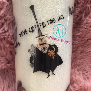 Puede incluir: Un vaso blanco con purpurina con una ilustraci&oacute;n en blanco y negro de un personaje de la pel&iacute;cula Pesadilla antes de Navidad. El texto "We've got to find Jack" est&aacute; impreso en el vaso. El vaso est&aacute; decorado con un dise&ntilde;o de purpurina azul y blanco.