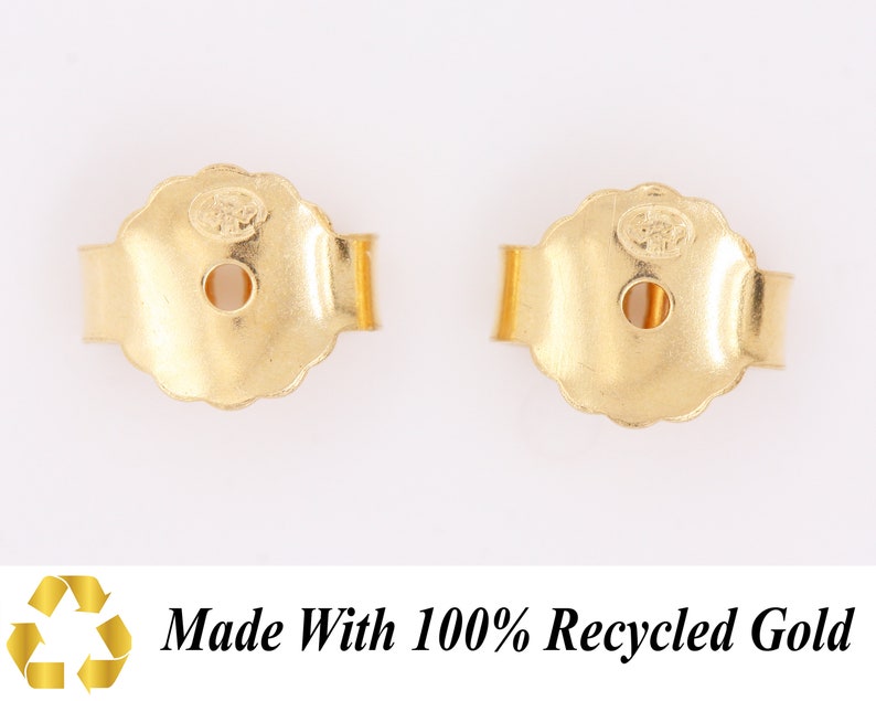 May include: Two gold-colored earring backs. The backs are made of metal and have a rounded shape with a small hole in the center. The backs are designed to secure earrings to the earlobe.  Made with 100% Recycled Gold.