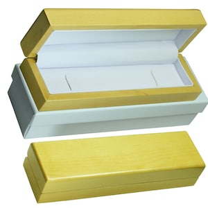 May include: Two wooden boxes, one open and one closed. The open box has a white interior and is made of light wood. The closed box is made of a darker wood.