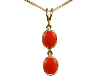 Può includere: Una collana con catena d'oro con un ciondolo con due pietre di corallo rosso.