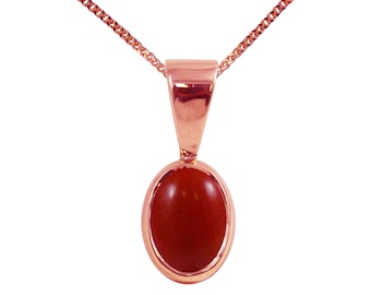 Può includere: Una collana con un ciondolo in oro rosa e una pietra ovale rossa.