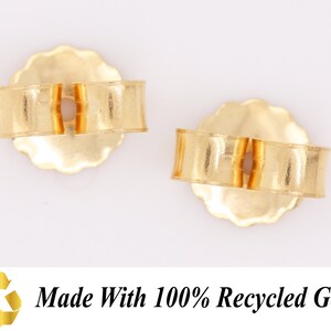 May include: Two gold earring backs made with 100% recycled gold. The backs are designed to fit over the post of an earring.