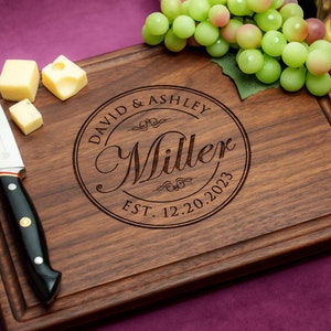 Handmade from natural hardwood personalized cutting board. Never stained, 100% food safe, only finished with food grade mineral oil and beeswax. 12x9 inches Walnut Wooden board with central design number 001 with first names, last name, and date.