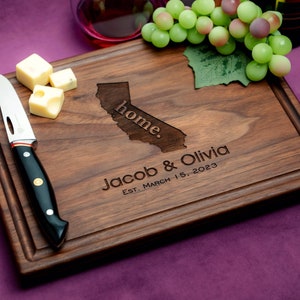 Handmade from natural hardwood personalized cutting board. Never stained, 100% food safe, only finished with food grade mineral oil and beeswax. 12x9 inches Walnut Wooden board with central design number 602 with US state, first names, and date.