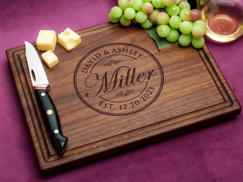 Handmade from natural hardwood personalized cutting board. Never stained, 100% food safe, only finished with food grade mineral oil and beeswax. 12x9 inches Walnut Wooden board with central design number 001 with first names, last name, and date.