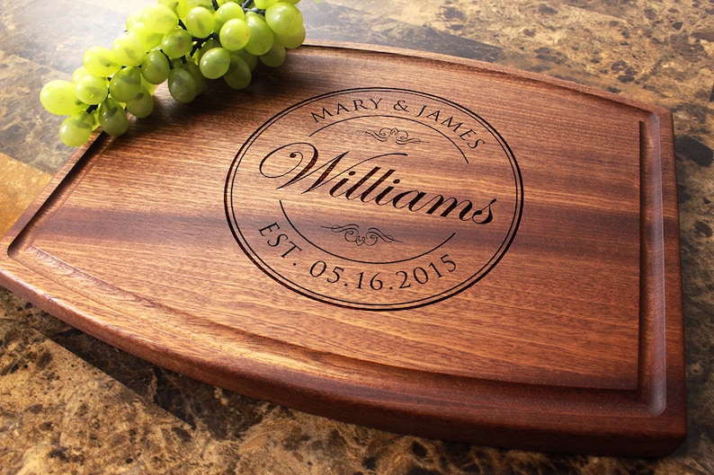 Handmade from natural hardwood personalized cutting board. Never stained, 100% food safe, only finished with food grade mineral oil and beeswax. 12x9 inches Arched Mahogany board with central design number 001 with first names, last name, and date.