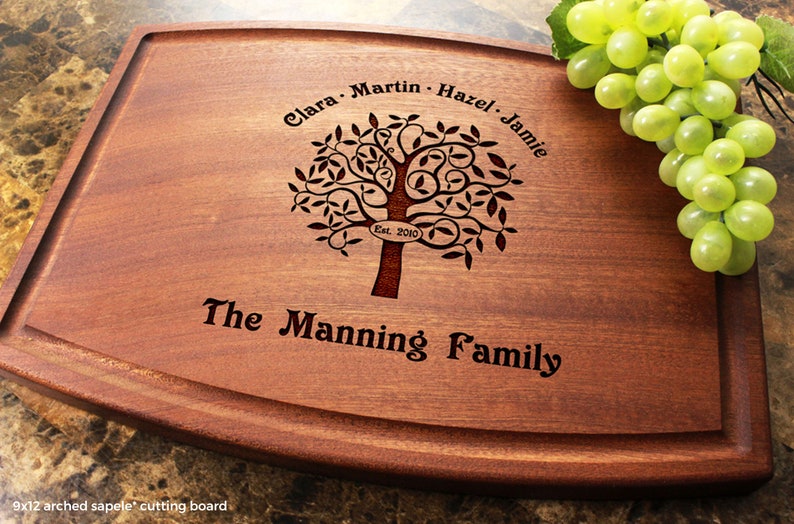 Handmade from natural hardwood personalized cutting board. Never stained, 100% food safe, only finished with food grade mineral oil and beeswax. 12x9 inches Mahogany Arched board with Family Tree design 402 with first names, date, and family name.