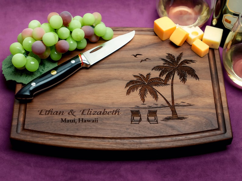 Handmade from natural hardwood personalized cutting board. Never stained, 100% food safe, only finished with food grade mineral oil and beeswax. 12x9 inches Walnut Arched Wooden board with palm trees and beach chairs design number 409.