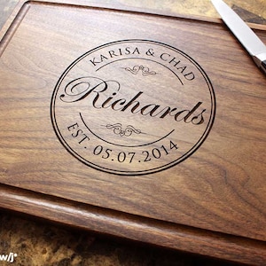 Handmade from natural hardwood personalized cutting board. Never stained, 100% food safe, only finished with food grade mineral oil and beeswax. 12x9 inches Walnut Wooden board with central design number 001 with first names, last name, and date.